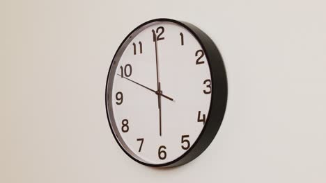 a close-up 4k shot of a black and white wall clock filling the frame, showing the time as 6:00.