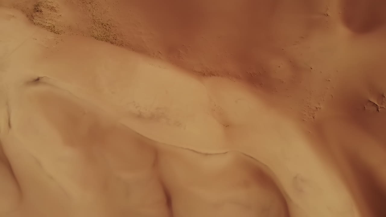 vista de arriba hacia abajo de los patrones de arena dorada del desierto