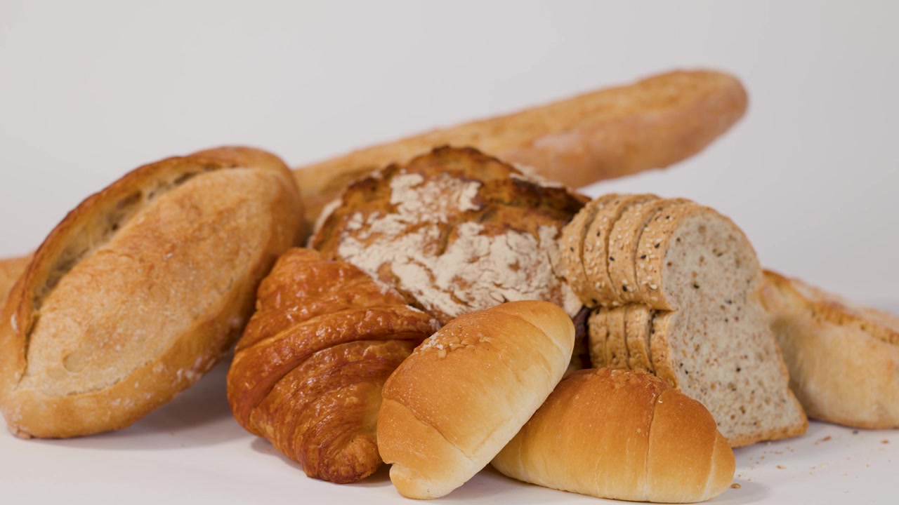Hand Selecting Freshly Baked Bread from an Assortment