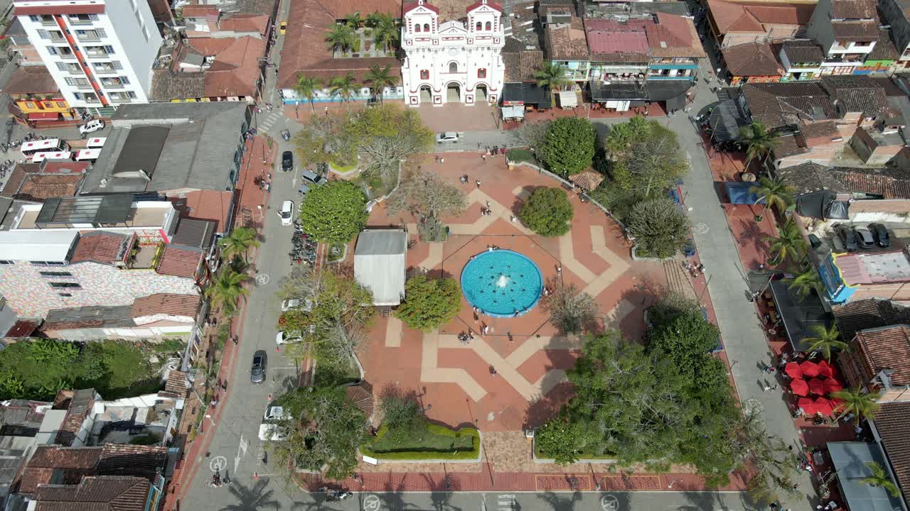 Bird's eye drone view of tradional colombian town of Guatape, Colombia, view on cathedral, square and residential buildings.