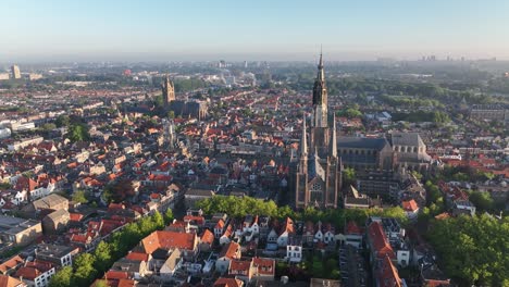 drone semi orbit left over the historic city of delft, netherlands, showcasing nieuwe kerk and surrounding architecture at sunrise