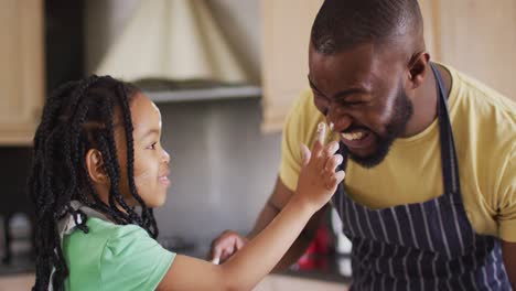 Glücklicher-Afroamerikanischer-Vater-Und-Tochter-Backen,-Spielen-Mit-Mehl-In-Der-Küche
