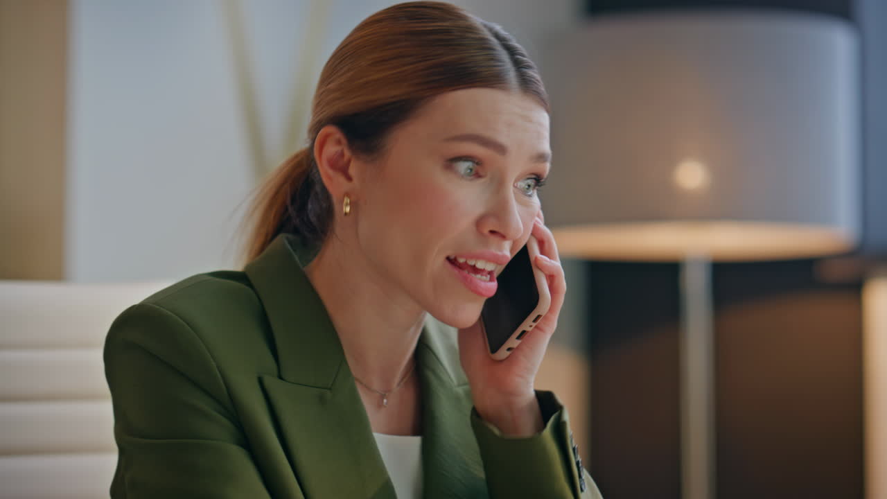 Emotional businesswoman answering call speaking mobile phone at cabinet closeup