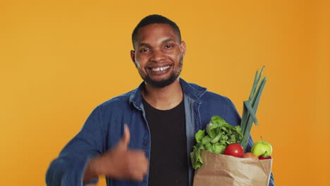 Cheerful-positive-guy-giving-a-thumbs-up-for-locally-grown-produce