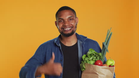 cheerful positive guy giving a thumbs up for locally grown produce