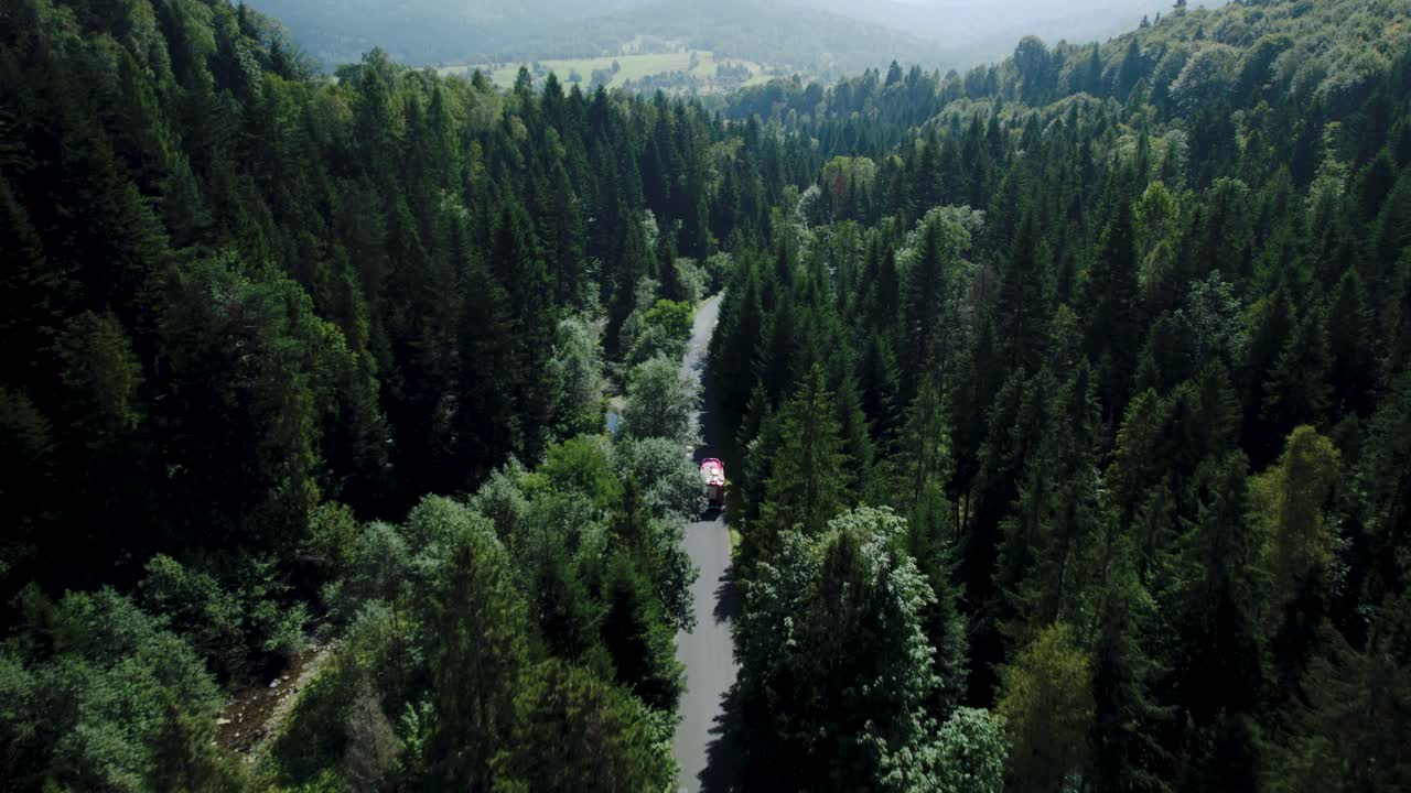 un drone de 4k de un camión de bomberos conduciendo en un impresionante paisaje forestal
