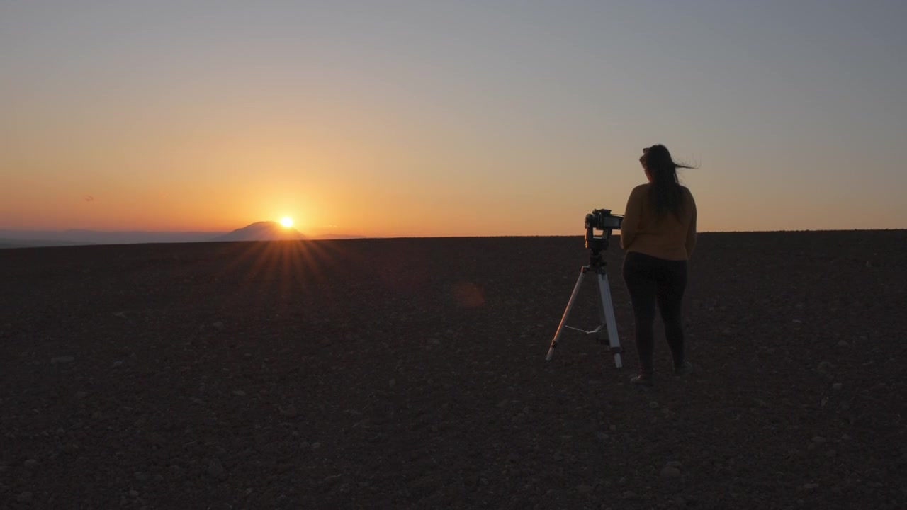 Filmatisk bilde av kvinne som filmer solnedgang