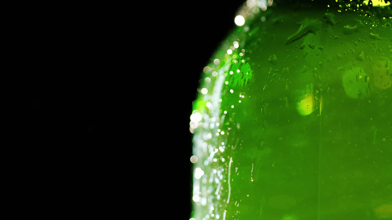 parte de una botella de cerveza fría gotas de condensado fluyen por el vaso sobre un fondo negro el libre