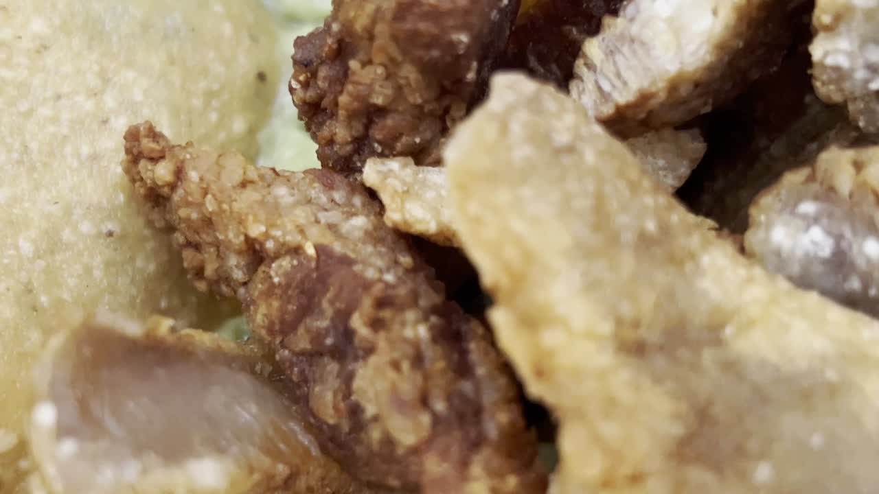 primer plano de un taco tradicional mexicano lleno de chicharrón crujiente, guacamole cremoso y fichas de tortilla doradas, capturando la esencia de la auténtica cocina mexicana, macro en cámara lenta