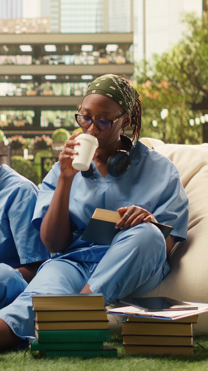Vertical Video Medical school peers in scrubs review laptop notes together on campus