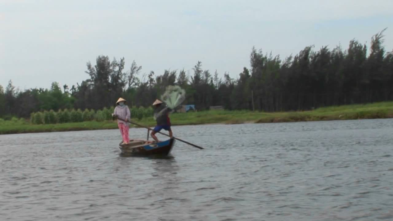 베트남 어부가 그물을 강에 던집니다.