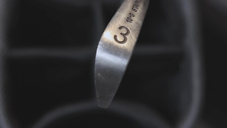 close-up shot of 3 iron golf club being place into a golf bag after being used