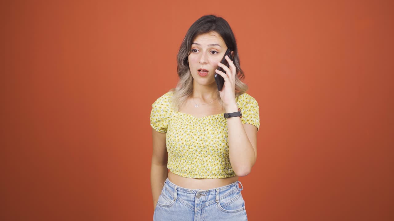 젊은 여성이 전화로 나쁜 소식을 듣고 화가 납니다.