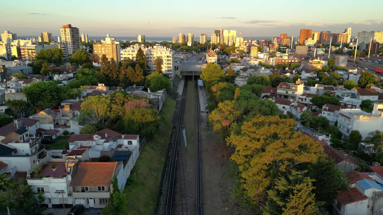 Vista aérea de vías de tren que atraviesan una ciudad durante la hora dorada