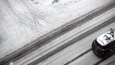 snowy road with tire tracks and footprints