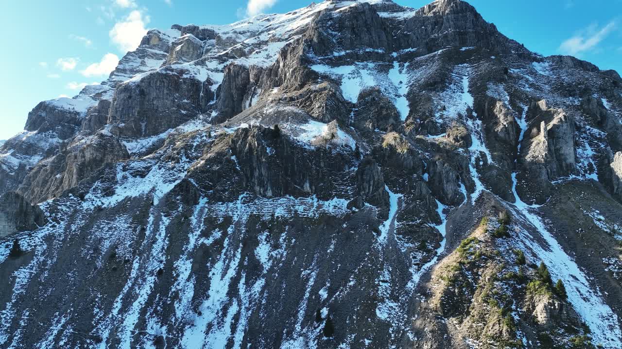 Drone video of a tall mountain covered in snow