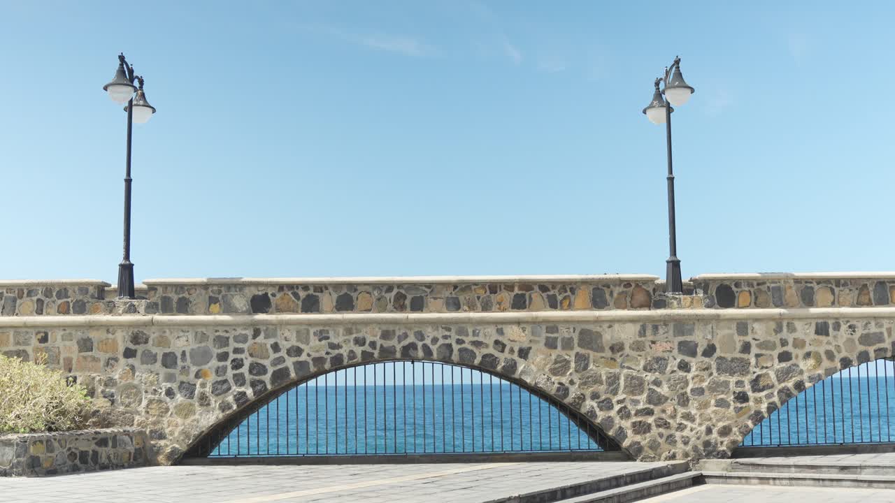 postes de lámpara y vieja pasarela de piedra cerca de la costa de la isla de tenerife