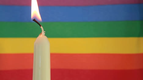 vela encendida contra la bandera del arco iris
