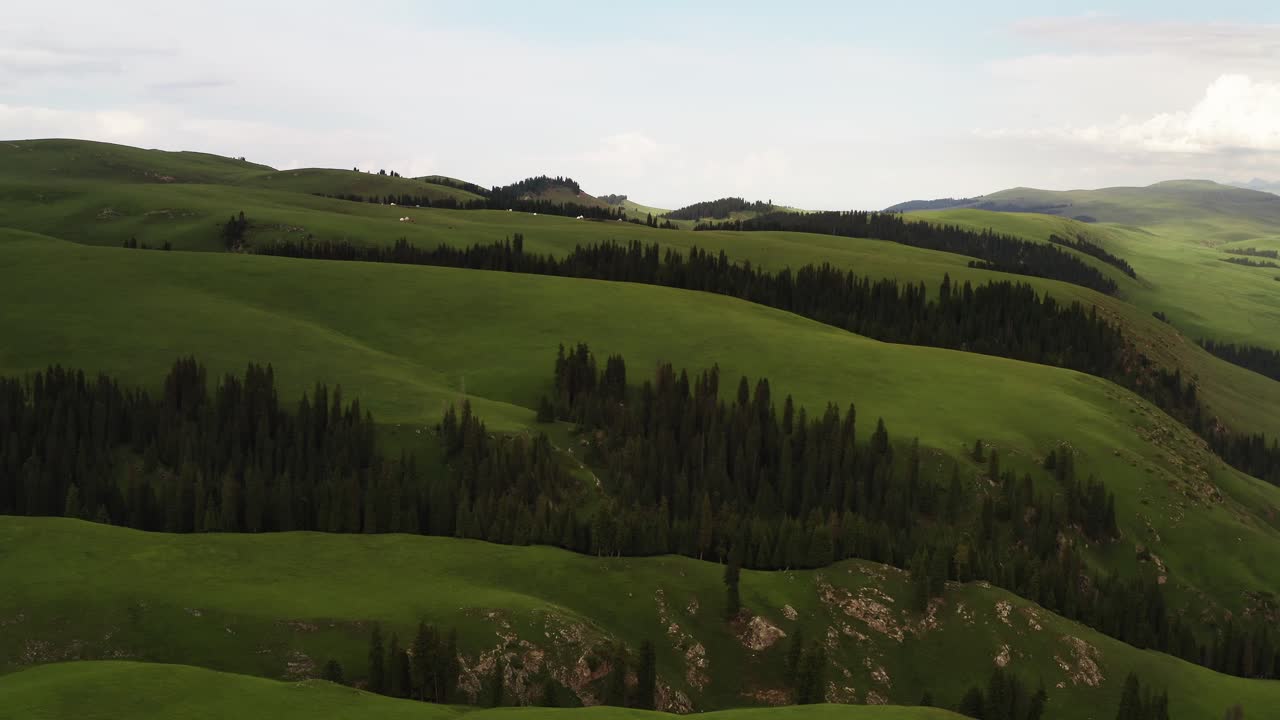 los picos de las montañas y las praderas están bajo nubes blancas.