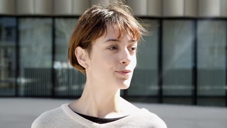 closeup view of serious young woman talking to someone on street