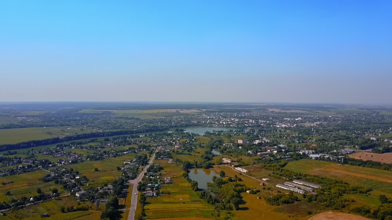 Beautiful scenery of countryside area on clear bright day. City view around the river at backdrop of blue sky. Top perspective.