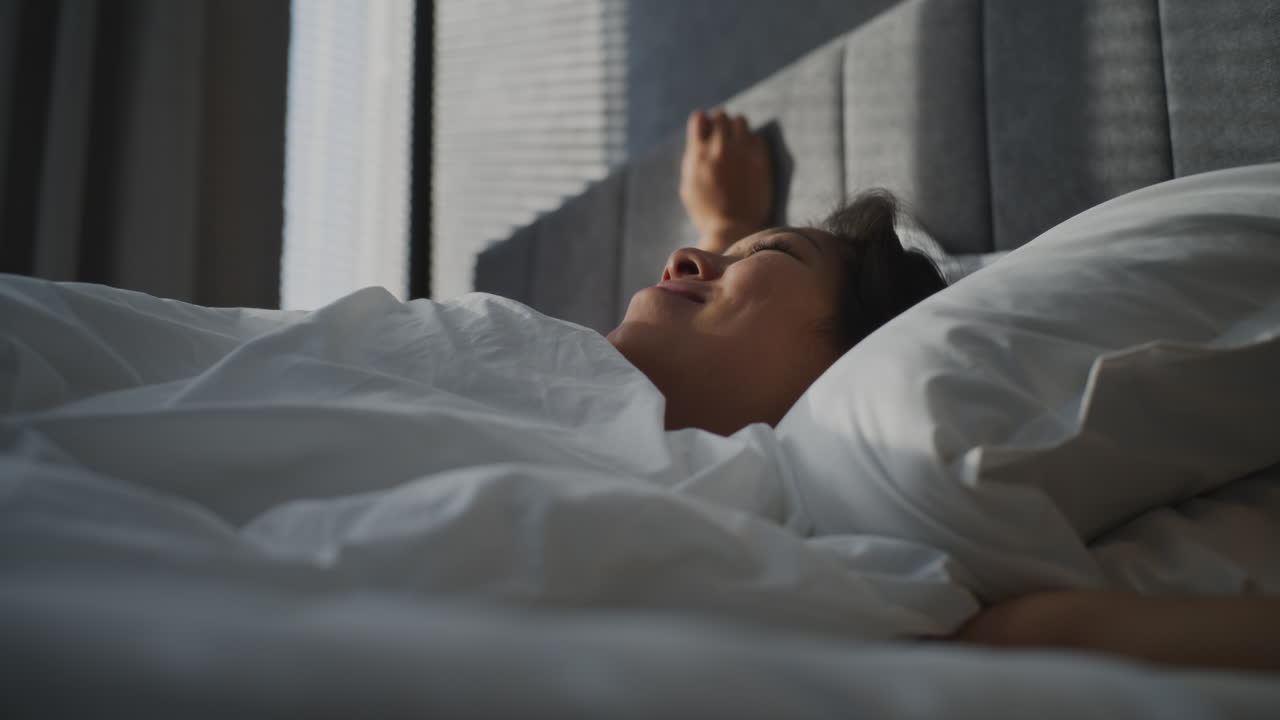 Woman sleeping and waking up in bed