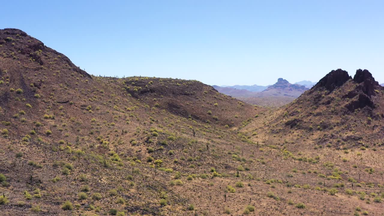 panorámica aérea lenta a la izquierda desde butte hasta la ladera del desierto con una vista de la montaña roja, la montaña mcdowell, en el espacio entre la butte y la ladera de la montaña, reserva india de salt river, scottsdale, arizona.