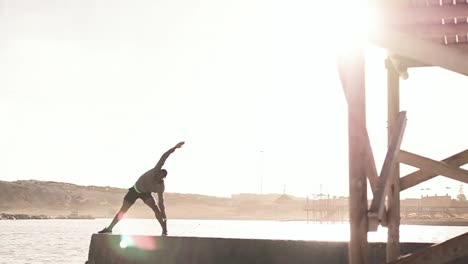 Hombre-Realizando-Ejercicios-De-Estiramiento-En-La-Playa