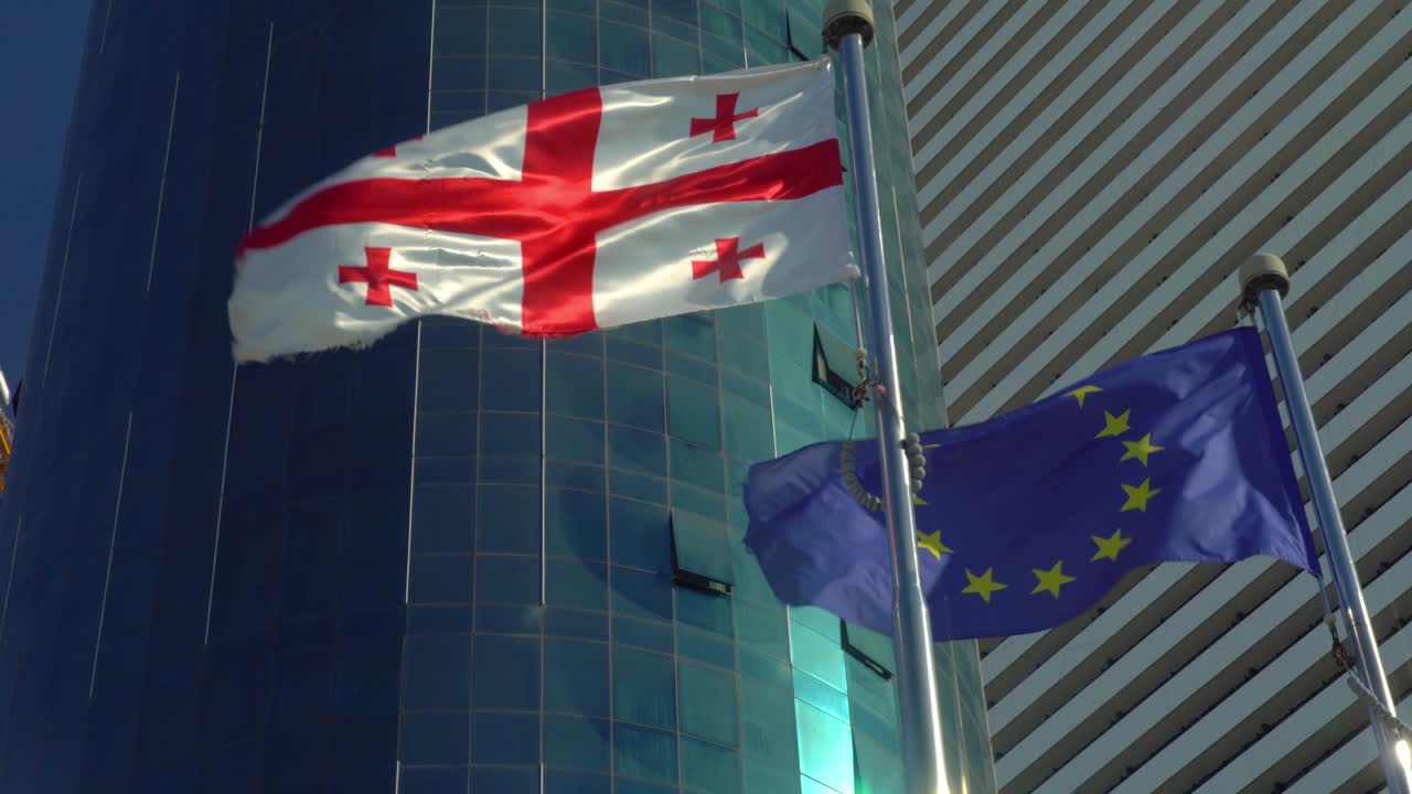 유럽과 조지아의 발은 은 날 건물과 하늘의 배경에 바람에 발달하고 있습니다.