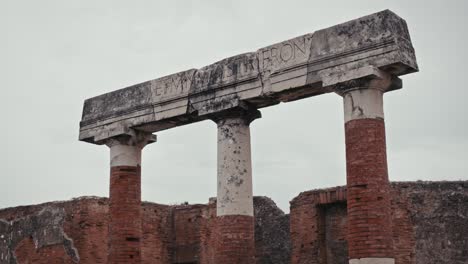 carved stone architrave atop ruins in pompeii, italy