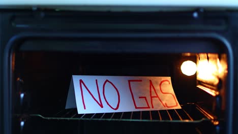 no natural gas. the man's hand opens the gas stove, where the sign is placed - no gas