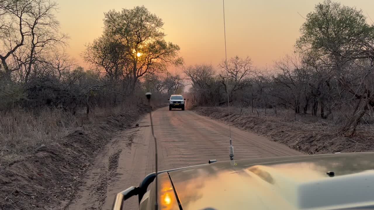 말라위 마제테 야생동물 보호구역에서 해가 뜨는 도로에서 사파리 차량.
