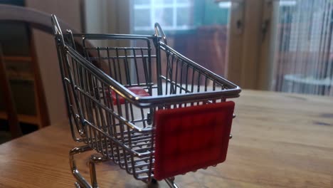 mini carrito de compras vacío concepto de entrega a domicilio en línea en la mesa de la cocina tire hacia atrás el enfoque superficial para desenfocar