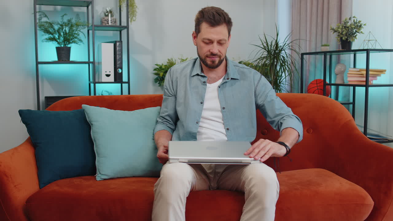 joven independiente comienza a trabajar en una computadora portátil, envía mensajes, hace compras en línea en casa