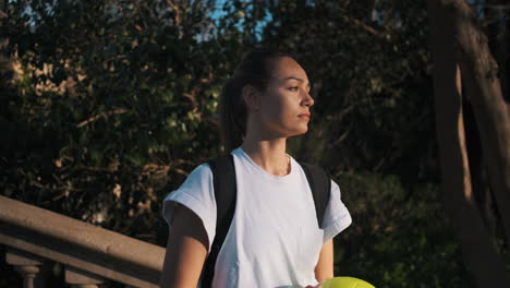 Cámara-Alejar-A-Una-Mujer-De-Fútbol-Con-Mochila-Jugando-Con-Una-Pelota-En-Las-Manos.