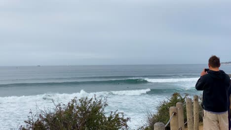 surfers riding some waves at cloudy day in s
