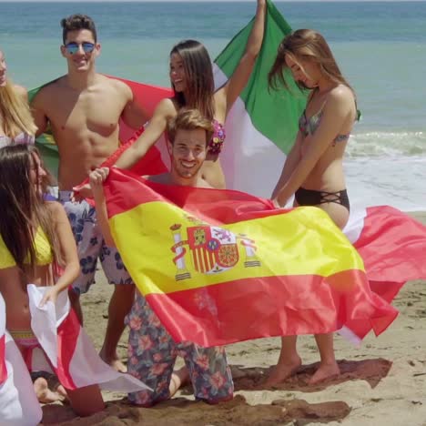 Gruppe-Von-Freunden-In-Badeanzügen-Mit-Flaggen-Am-Strand