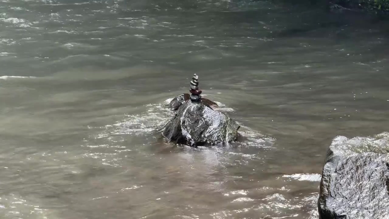 Stone Cairn Balanced on Rock in Flowing River