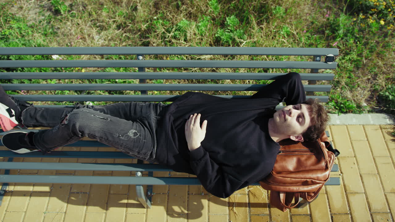 Tired Student Sleeping On The Park Bench After School