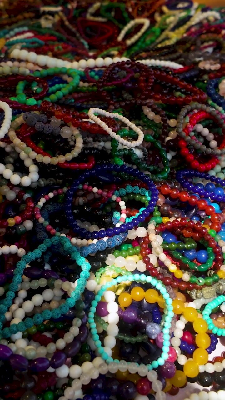 Una vivace collezione di braccialetti fatti a mano con pietre preziose e perline di vetro esposti in un mercato locale a Gdynia. Perfetto per contenuti di moda, vendita al dettaglio e viaggi