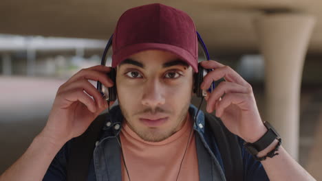 close up attractive young hispanic man portrait of student listening to music on headphones