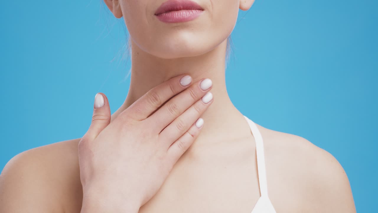 una mujer comprobando su garganta.