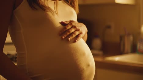 candid moments of anticipation: a close-up of a pregnant individual in a softly lit kitchen, reflecting the beauty and emotion of pregnancy