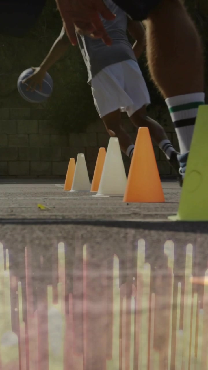 Video vertical: Piernas en primer plano moviéndose en la cancha, un jugador de baloncesto driblando, comenzando a correr y esquivando conos.