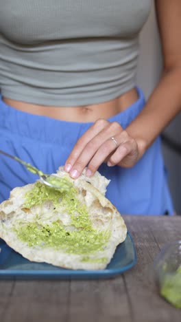 mujer preparando y comiendo un sándwich saludable