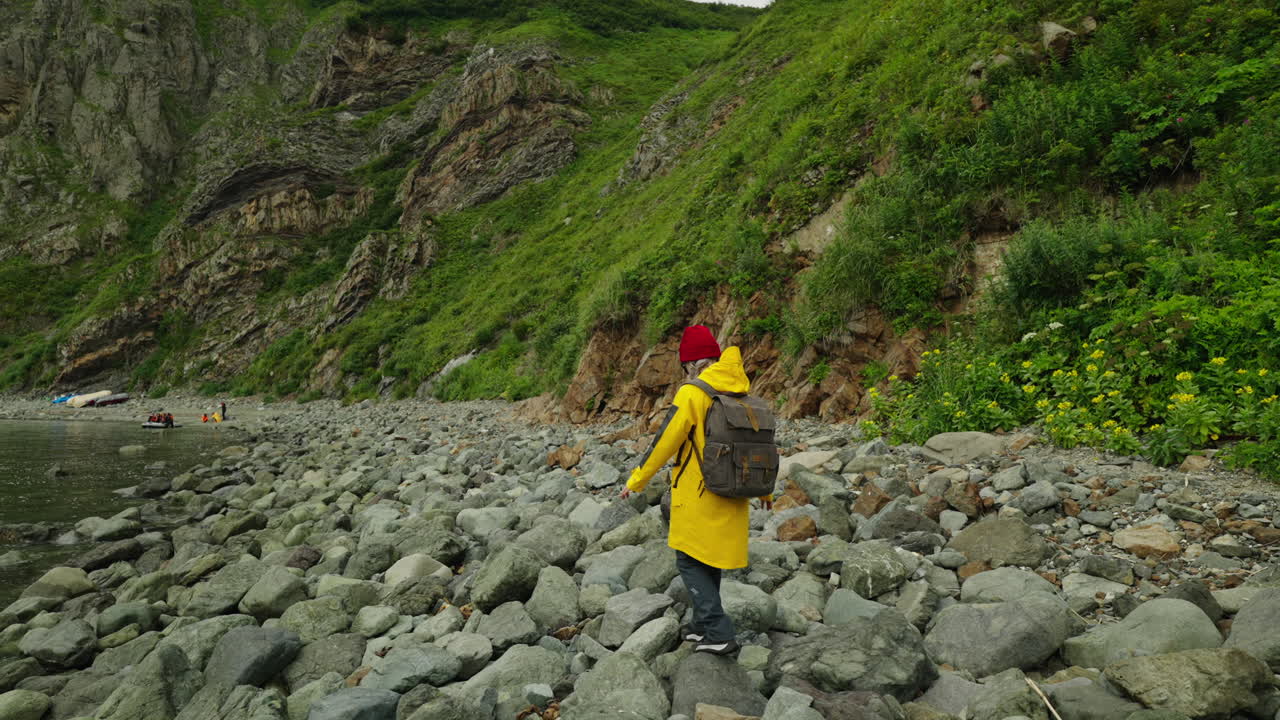Person Hiking on Rocky Coastline