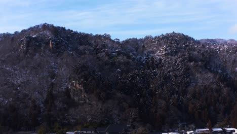 yamadera in winter, aerial tilt reveal of snowy japan landscape 4k