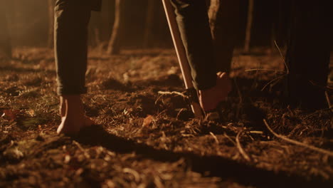 barefoot digging in the forest at night