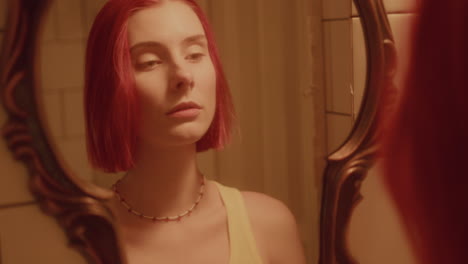 young beautiful woman looking in mirror in bathroom filled with golden light