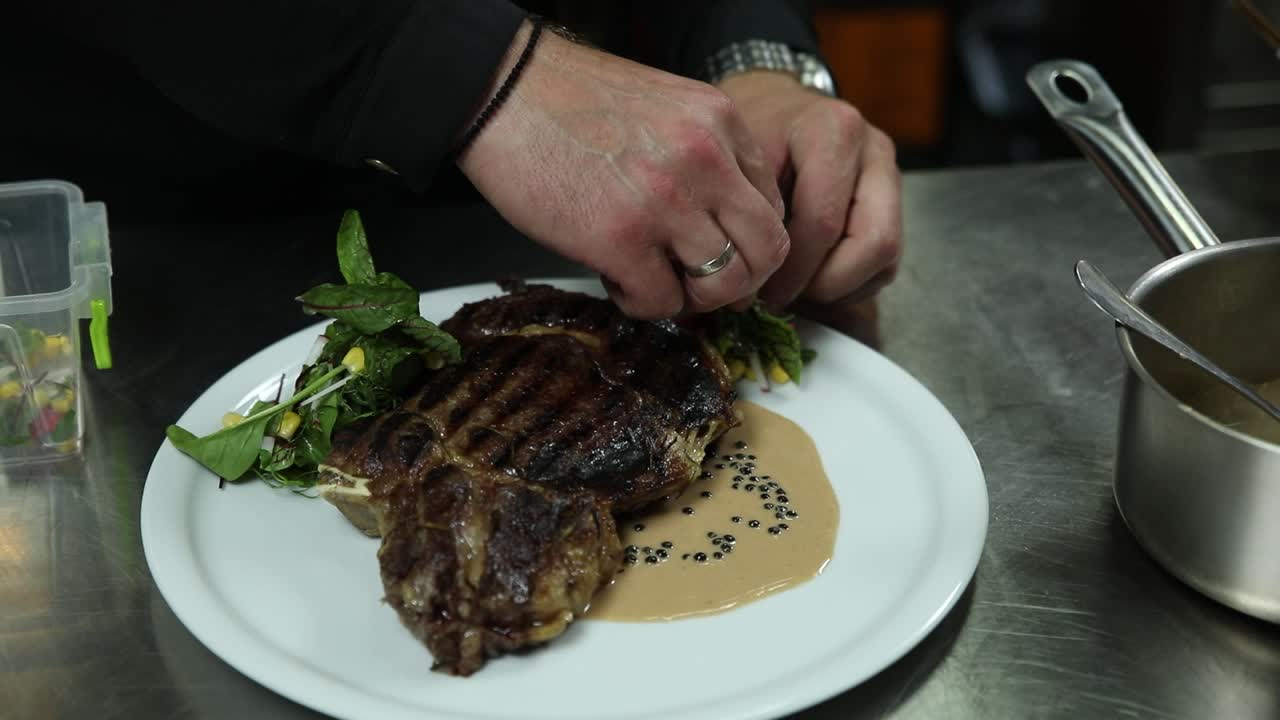 chef preparando un plato de bistec gourmet